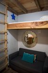 The small fold out couch and lofted bed
